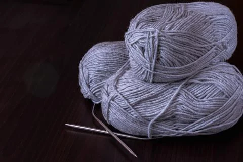 Hobbies and creative activities concept - three skeins of gray yarn with meta 스톡 사진