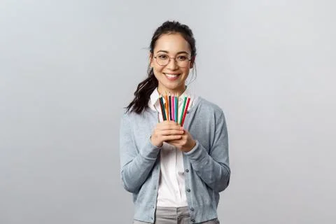 Hobbies, creativity and art concept. Upbeat asian woman in glasses inviting to Stock Photos