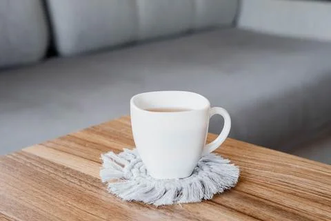 Hobby handmade macrame. Tea in a cup on a gray macrame Stock-Fotos