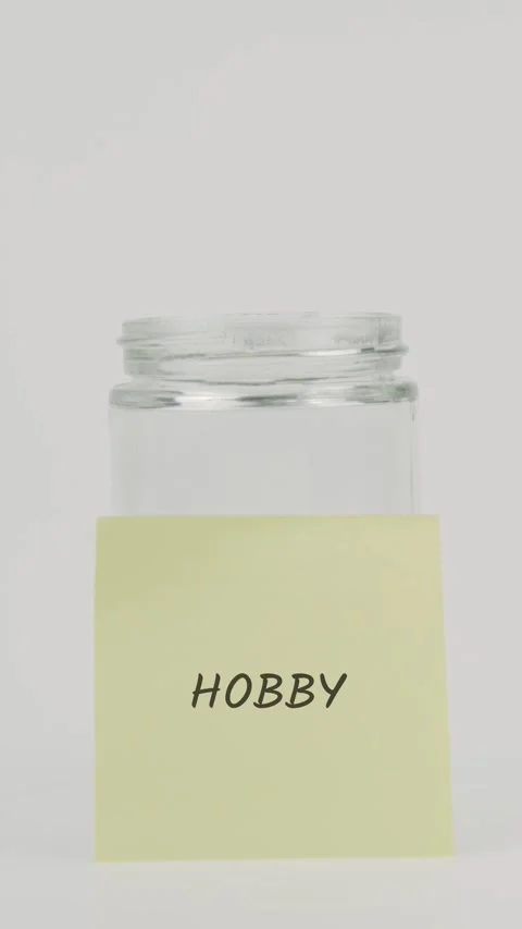 Hobby text or word on yellow sticky note attached to glass jar with hand Stock Footage 311741182