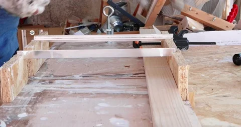 Hobbysta using hand held worm drive circular saw to cut boards on a new handc Vídeos de archivo 161278081