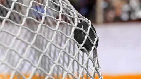 Hockey puck flies into the net on a hockey boards with a yellow stripe. Stock Footage 88183025