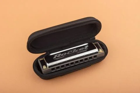 Hohner professional diatonic Rocket harmonica lies in an open black case.  On Stock Photos