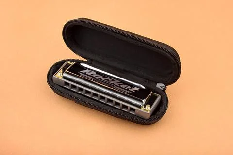 Hohner professional diatonic Rocket harmonica lies in an open black case.  On Stock Photos