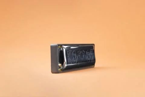 Hohner Rocket professional diatonic harmonica sideways.  On a light brown bac Stock Photos