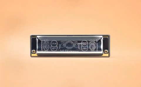 Hohner Rocket professional diatonic harmonica backside.  On a light brown bac Stock Photos
