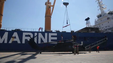 Hoist being lowered onto helicopter for loading onto ship Stock Footage 90417641