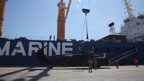 Hoist being lowered onto helicopter for loading onto ship Stock Footage 90417661