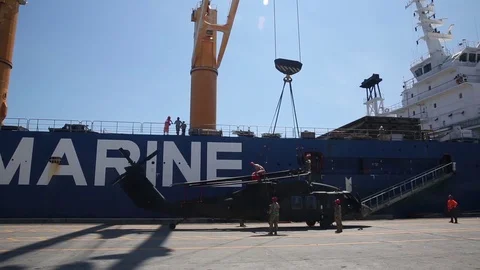 Hoist being lowered onto helicopter for loading onto ship Stock Footage 90417673