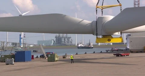 Hoisting wind turbine rotor blades on board an offshore construction vessel Stock Footage