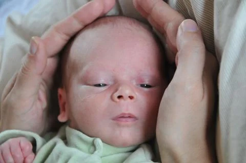 Hold a baby's head between both hands Stock Photos