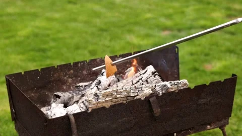 Hold bread over the barbecue. Cooking bread on a skewer on the grill. Stock Footage 130589214