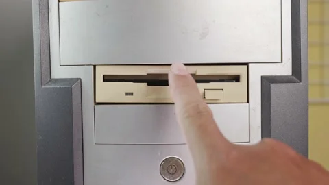 Hold the Floppy A disc and insert the reader. to read and write data It's tec Video stock 196262373