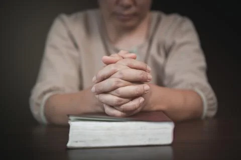 Hold hands in prayer on the scriptures. Pray to God. Believe in the good. Fai Foto stock