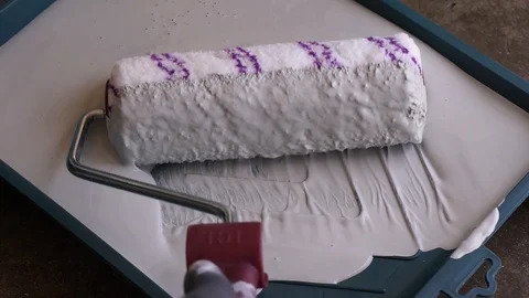 Hold the paint roller with the gloves on the paint tray Stock Footage 129279633
