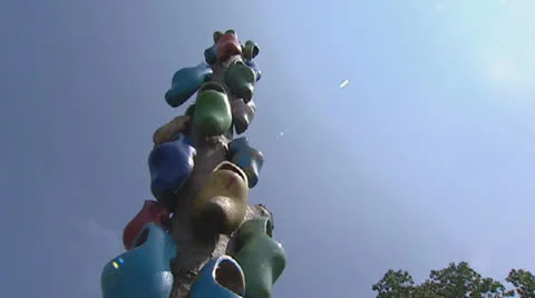 Hold + pan totem with wooden shoes - blue sky Stock Footage