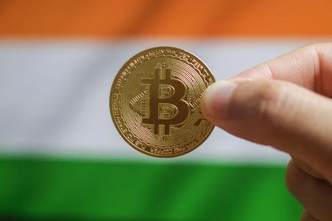 Hold the physical version of Bitcoin (the new virtual currency) and the Ind.. Stock Photos