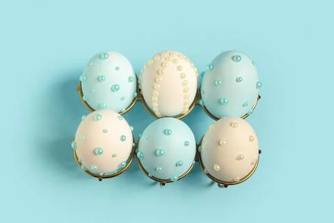 Holder and Easter eggs decorated with pearls on blue background Stock Photos