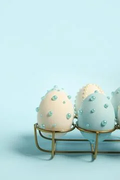 Holder and Easter eggs decorated with pearls on blue background Stock Photos