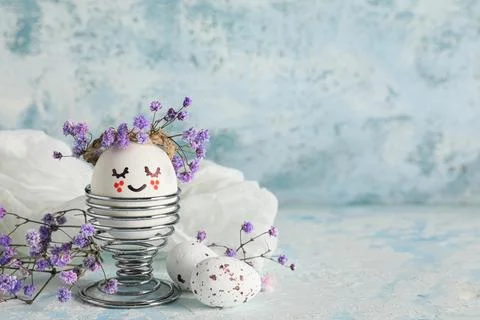 Holder of creative Easter egg with flowers on grunge blue background Stock-Fotos