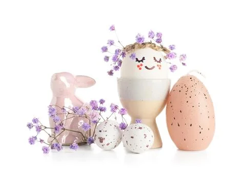 Holder with creative Easter eggs, decorative rabbit and flowers isolated on w Stock Photos