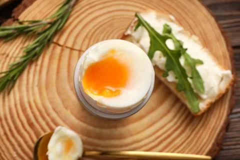 Holder of soft boiled egg and bread slice with cream cheese and arugula leave Stock Photos