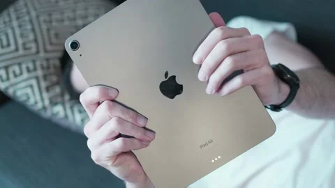 Holding and Using an Apple iPad Tablet While Relaxing on the Couch Stock Footage 180053991