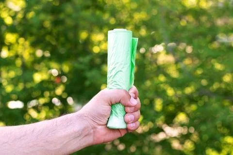 Holding bio eco plastic garbage bag in roll Stock Photos