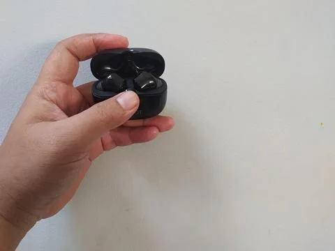 Holding bluetooth headset box black color Stock Photos