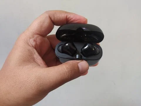 Holding bluetooth headset box black color Stock Photos