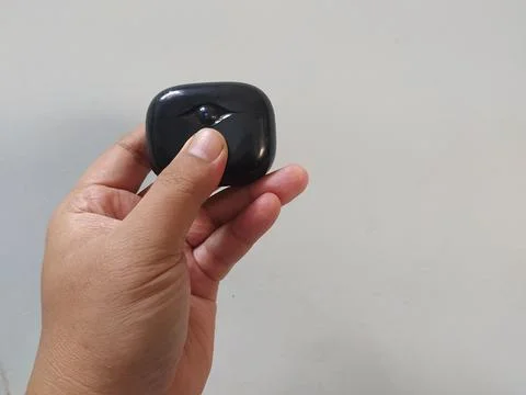 Holding bluetooth headset box black color Stock Photos