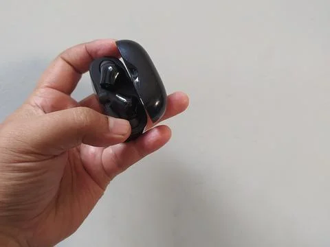Holding bluetooth headset box black color Stock Photos