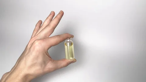 Holding bottles on white background. CBD pipette.  Bottle of Cannabis oil. Oil Video stock 122699796