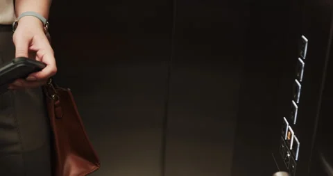 Holding briefcase, person pressing elevator buttons in office building Vídeos de archivo 297650951