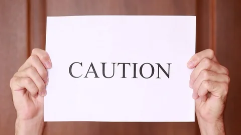 Holding "Caution" sign overhead 動画素材 92936586