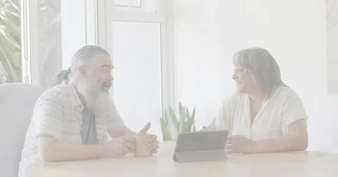Holding ceramic mug, tapping tablet, bearded man and woman in short sleeves Stock Photos