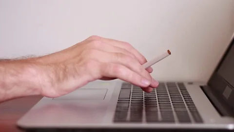 Holding cigarette and working on the computer 動画素材 81057784