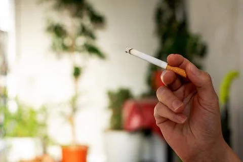 A is holding a cigarette. Stock Photos
