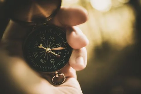 Holding a Compass While Exploring Nature in a Forest During Golden Hour Stock Photos