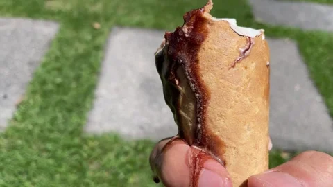 Holding crispy ice cream cone chocolate melting on fingers outdoor sunny day Video stock 249587739