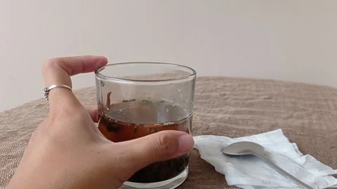 Holding a cup of tea on a brown table Stock Footage 145629883