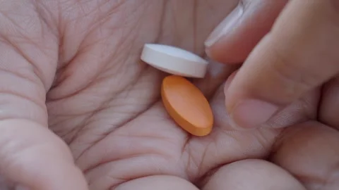 Holding different colored pills in a hand Stock Footage 336769808