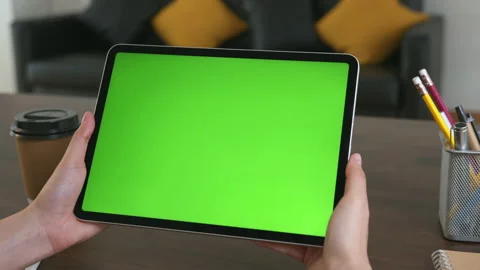 Holding digital tablet with green screen and touch device browsing Internet. 스톡 동영상 135503494
