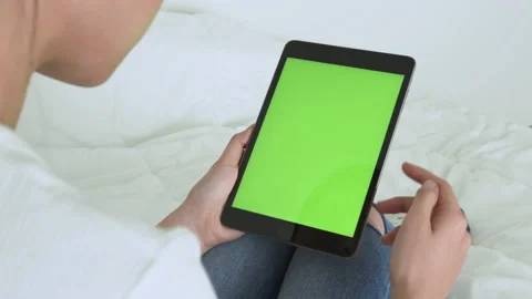 Holding digital tablet with green screen and touch device browsing Internet. 스톡 동영상 135503577