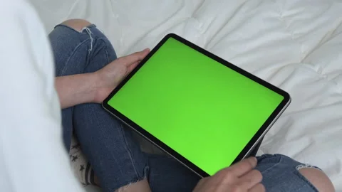 Holding digital tablet with green screen and touch device browsing Internet. 스톡 동영상 135504095