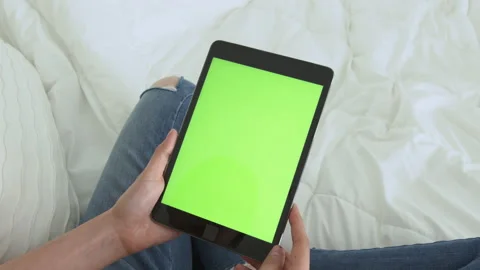 Holding digital tablet with green screen and touch device browsing Internet. 스톡 동영상 135504539