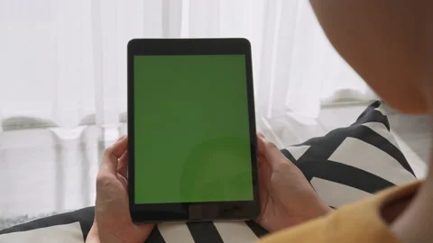 Holding digital tablet with green screen and touch device browsing Internet. 스톡 동영상 135505711