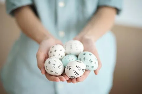 Holding Easter eggs with hand-drawn patterns Stock Photos