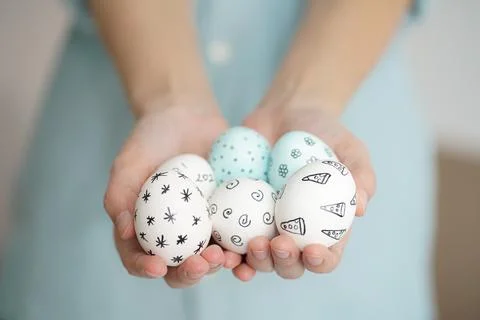 Holding Easter eggs with hand-drawn patterns Stock Photos