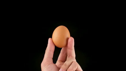 Holding an egg in her hands. Black background. Close up Stock Footage 144655156